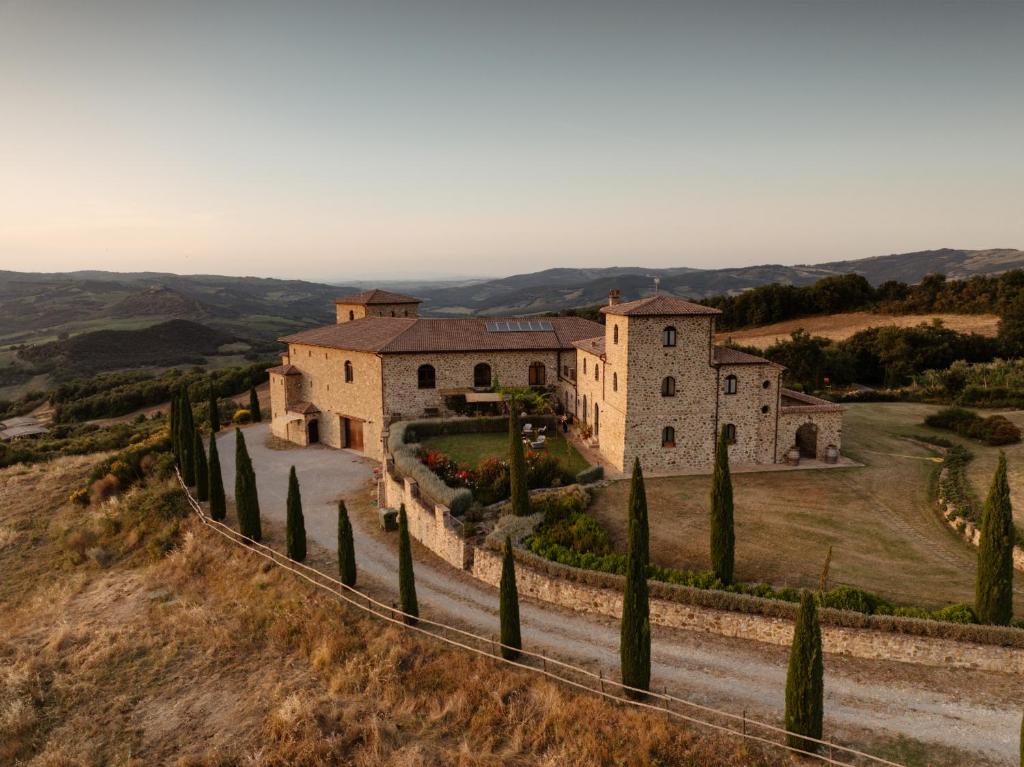 an estate on a hill with trees and a road at Podere Montale Winery in Seggiano