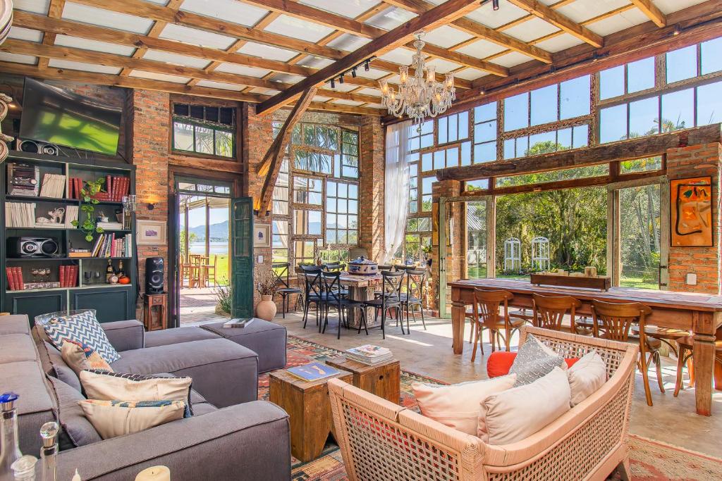 a living room with couches and a dining room at Vieja Hacienda in Praia do Rosa