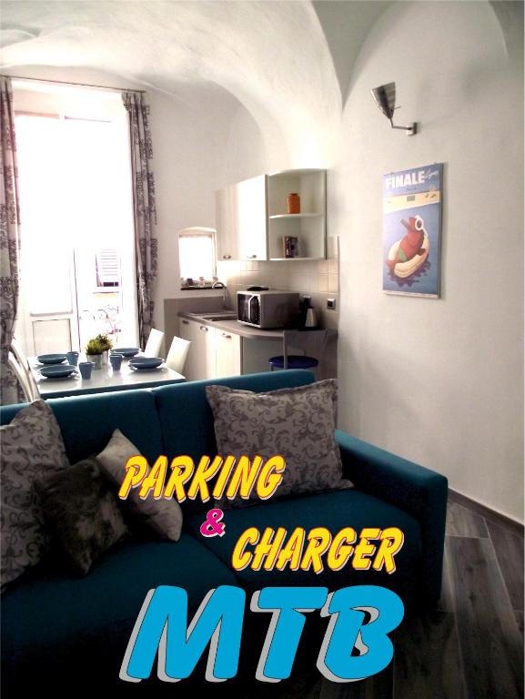 a living room with a blue couch with the words parking cheaper at Casa Bartelli in Finale Ligure