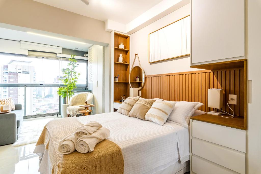 Hotel LUXO Brooklin AIR Studio Charme Boho com Vista Incrível, a bedroom with a bed with towels on it at LUXO Brooklin AIR Studio Charme Boho com Vista Incrível in São Paulo