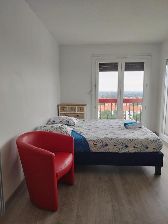 une chambre avec un lit et une chaise rouge dans l'établissement Les CHAMBRES de PERPIGNAN, à Perpignan
