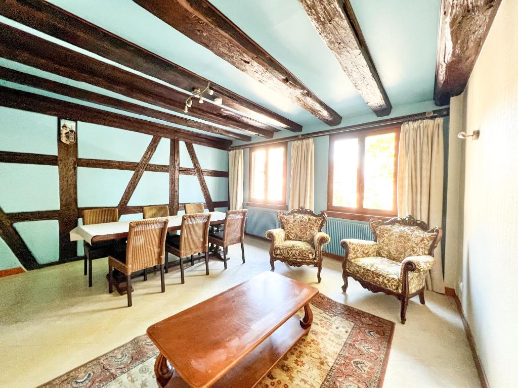 a living room with a table and chairs at Central & quiet, Full apt for 8 Trésor caché in Colmar