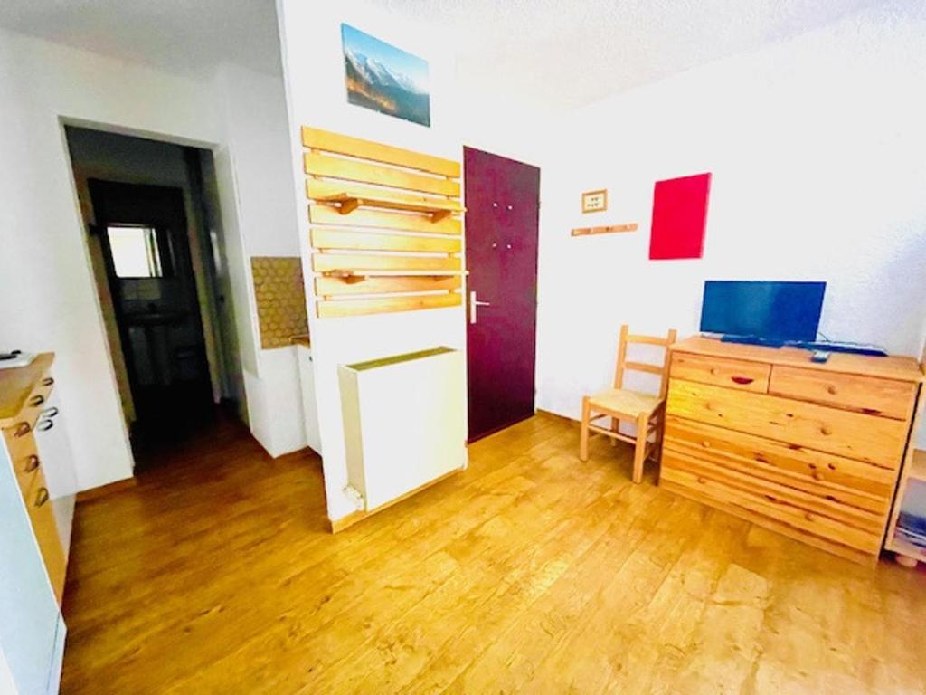 Cette chambre dispose de parquet et d'une commode en bois. dans l'établissement Charmant 2 pièces au pied des pistes, balcon sud/ouest, centre station - FR-1-516-88, à Les Deux Alpes