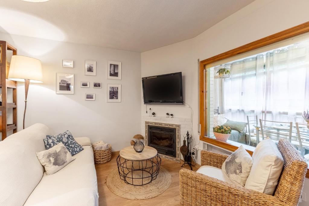 a living room with a white couch and a fireplace at Cumbre Escondida in Pelayos de la Presa
