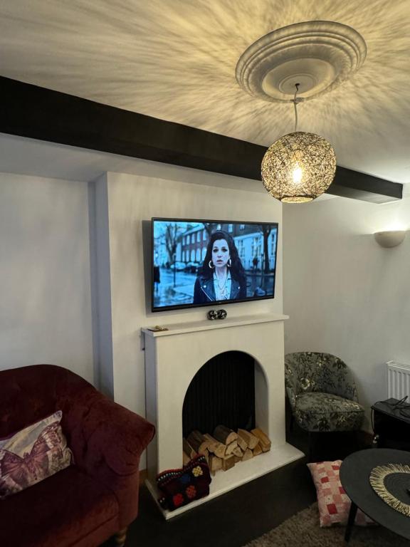 een woonkamer met een tv boven een open haard bij 2 bedroom cottage Brecon sleeps 4 in Brecon