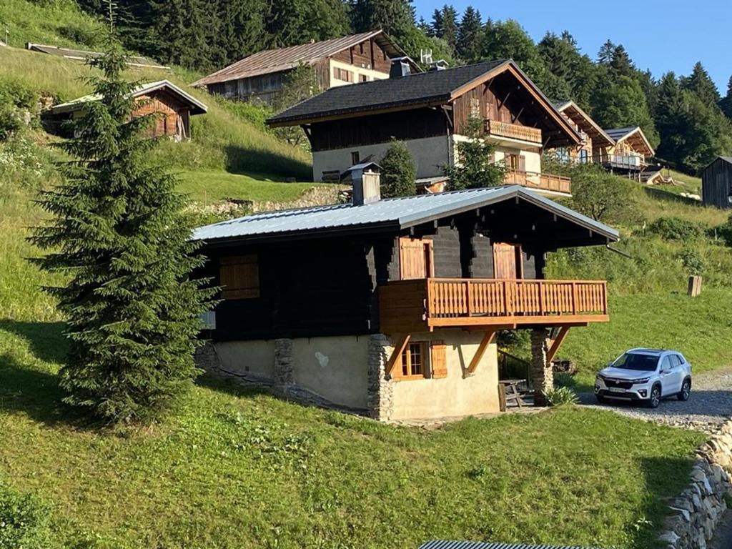 une maison sur une colline avec une voiture garée devant dans l'établissement Chalet cosy à Crest-Voland – 6 personnes, cuisine équipée, salon TV, proche pistes et nature - FR-1-733-154, à Crest-Voland