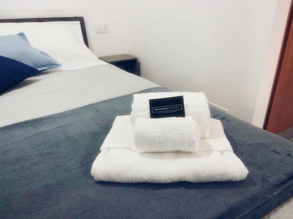 a pile of towels sitting on top of a bed at San Giovanni Apartment in Catanzaro