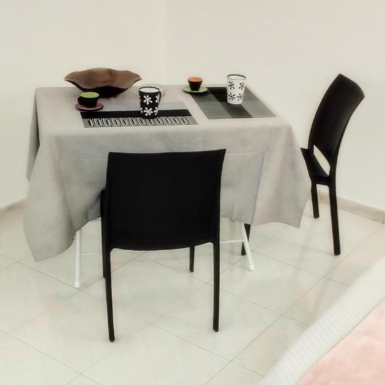 a table with two chairs and a table with cups on it at San Giovanni Apartment in Catanzaro