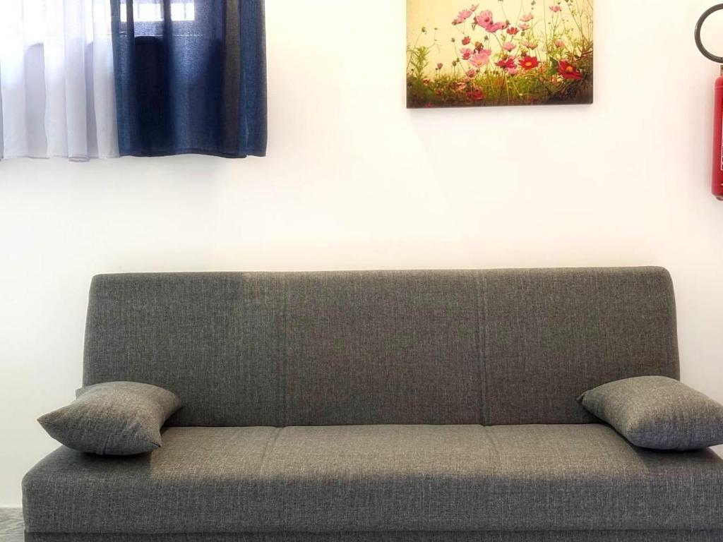 a couch in a living room with a painting on the wall at San Giovanni Apartment in Catanzaro