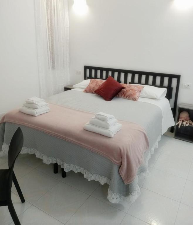 a bedroom with a large bed with towels on it at San Giovanni Apartment in Catanzaro