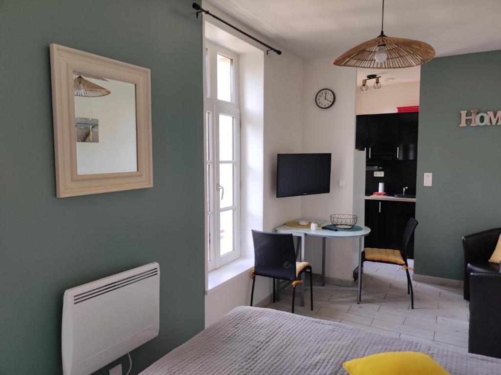 une chambre avec un lit, un bureau et une télévision dans l'établissement SCI les THERMES 17, à Rochefort