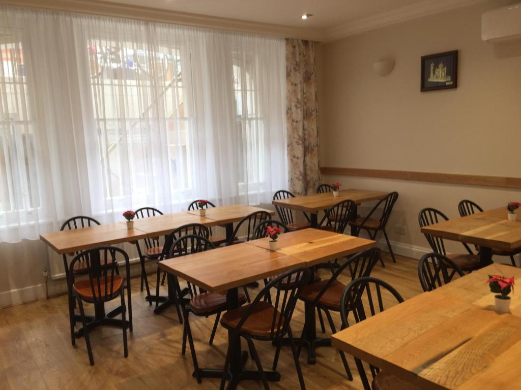 Un comedor con mesas y sillas de madera. en St Simeon, en Londres