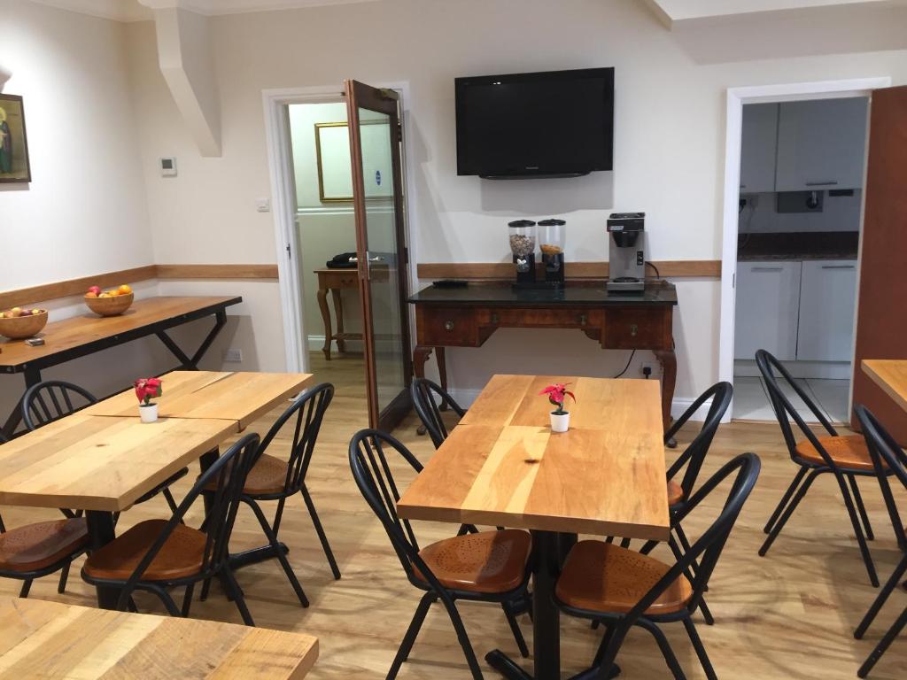 Habitación con mesas, sillas y TV. en St Simeon, en Londres