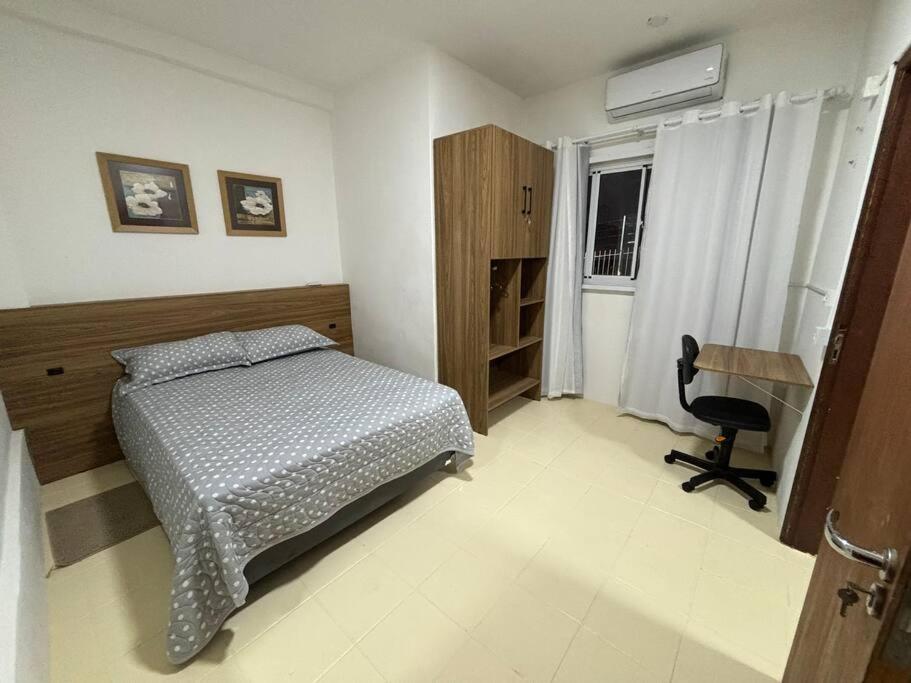 a bedroom with a bed and a desk and a chair at Cantinho do Mané in Florianópolis