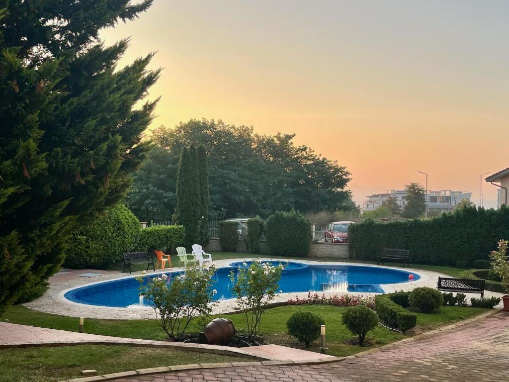 a swimming pool in a yard with trees and bushes at Apartment Sunny Seasons Byala in Byala