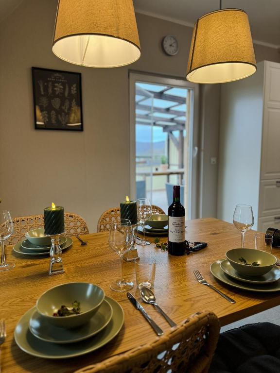 a wooden table with plates and glasses and a bottle of wine at Villa Herzog in Bad Sooden-Allendorf