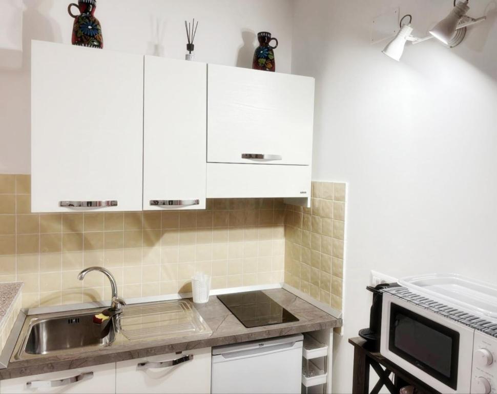 a kitchen with white cabinets and a sink at San Giovanni Apartment in Catanzaro