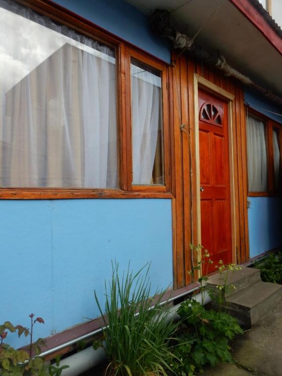 a blue house with a door and a window at El Jardin in Puerto Natales