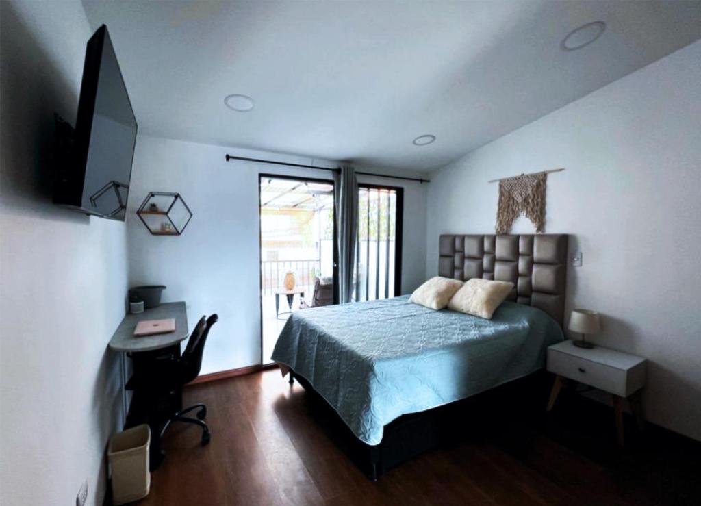 une chambre avec un lit, un bureau et une fenêtre dans l'établissement Posada Botero, à San Andrés