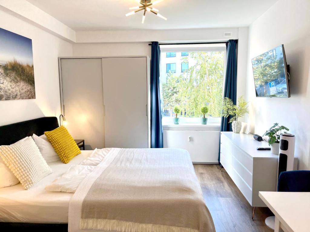 a bedroom with a large bed and a window at Beach&City Bude inkl Saisonstrandkorb in Grömitz
