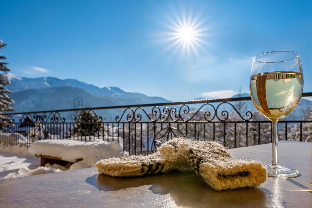 考斯赛力克Willa u podnóża Tatr Cztery Pory Roku的桌子上放着一杯葡萄酒和一个羊角面包。