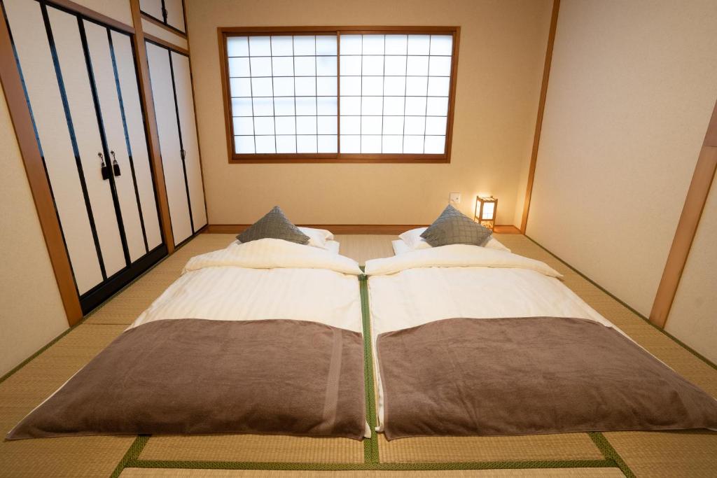Postel nebo postele na pokoji v ubytování 大吉屋 ワンフロア貸切旅館名古屋駅圏内
