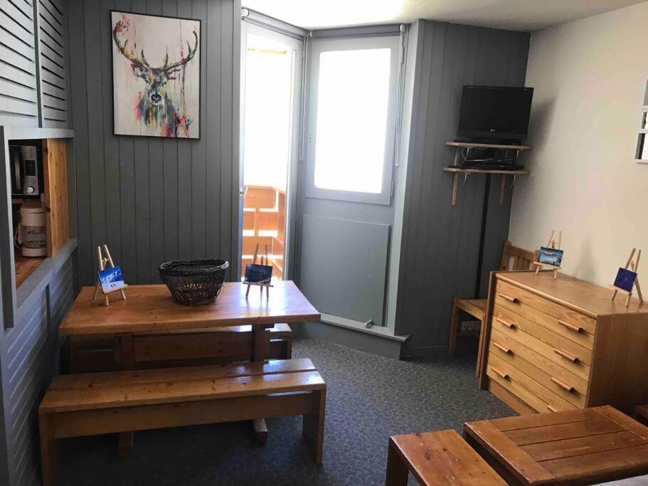 Cette chambre comprend un bureau, une table et une fenêtre. dans l'établissement BOR52 - BEAU T2 Rénové - pied des pistes- VAL CLARET, à Tignes