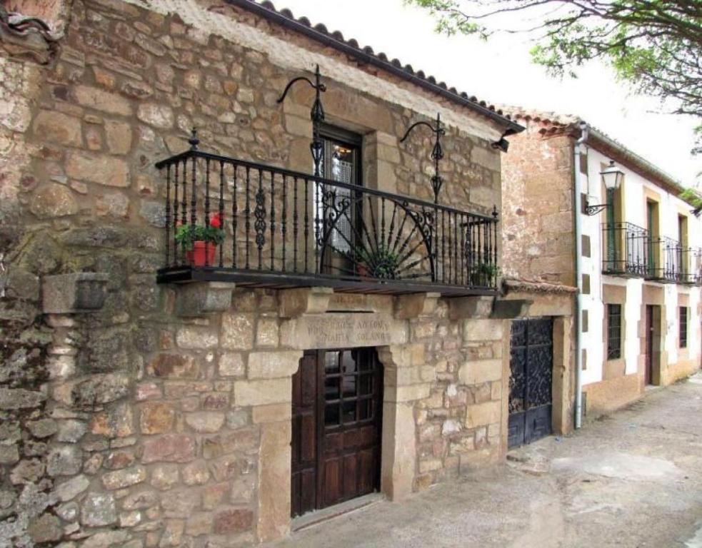 un edificio de piedra con balcón y puerta en Las Frascuelas, en Almajano