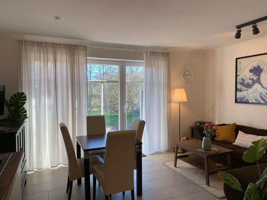 a living room with a table and a dining room at Haus-am-See-Kolkstr-1-EG-rechts in Norddeich