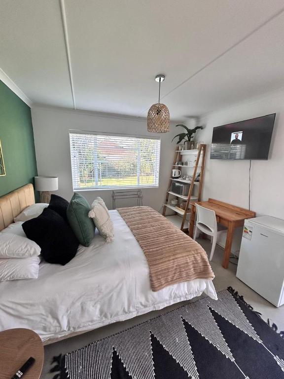 a bedroom with a large bed and a desk at Bottlebrush Guest Suite - close to Greenacres Hospital, Free WiFi, Parking, private in Gqeberha