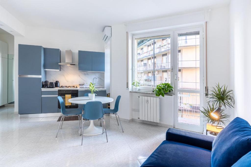 Una sala de estar con un sofá azul y una mesa. en Dreams Little Apartment - M5 Station - Near Center, en Milán