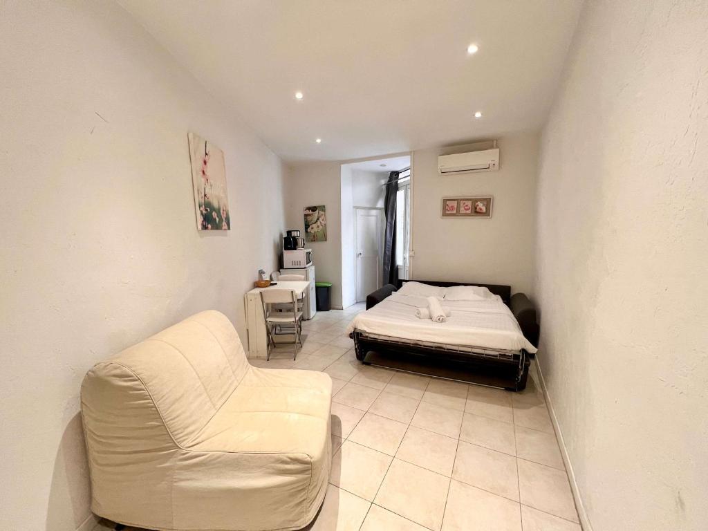 une chambre avec un lit, un canapé et une chaise dans l'établissement A043-Functional Studio Downtown Cannes, à Cannes