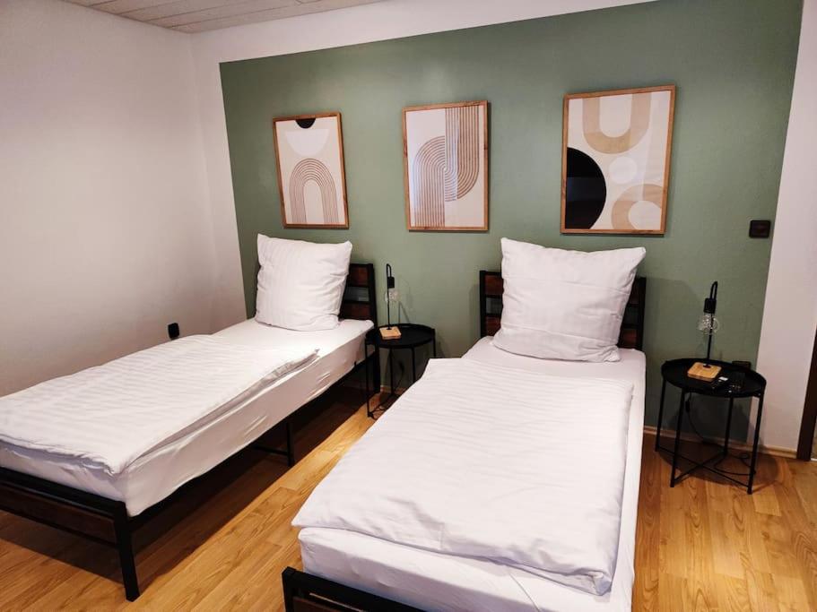 魏登Charmantes 2 BR Apartment mit Parkplatz的墙上有三张照片的房间的两张床