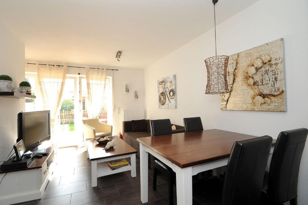 Una sala de estar con una mesa de comedor con sillas. en Taddel, en Norddeich