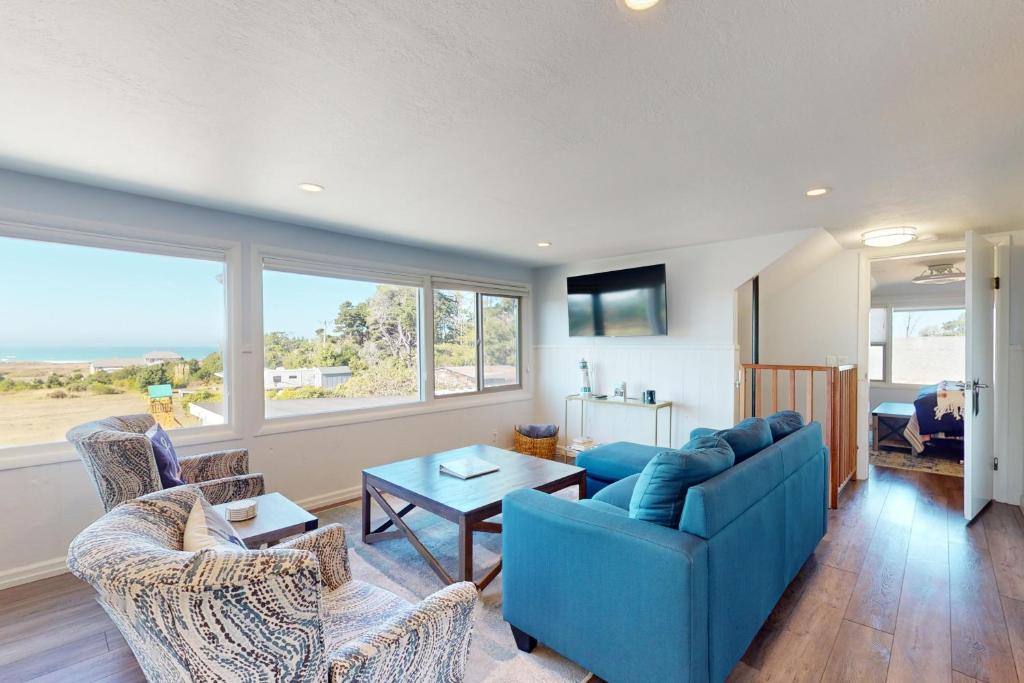 a living room with a blue couch and chairs at Sea Esta in Fort Bragg