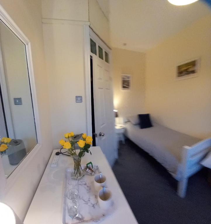 a room with a table with a vase of flowers on it at 2 Bodwen Villas in Llangollen