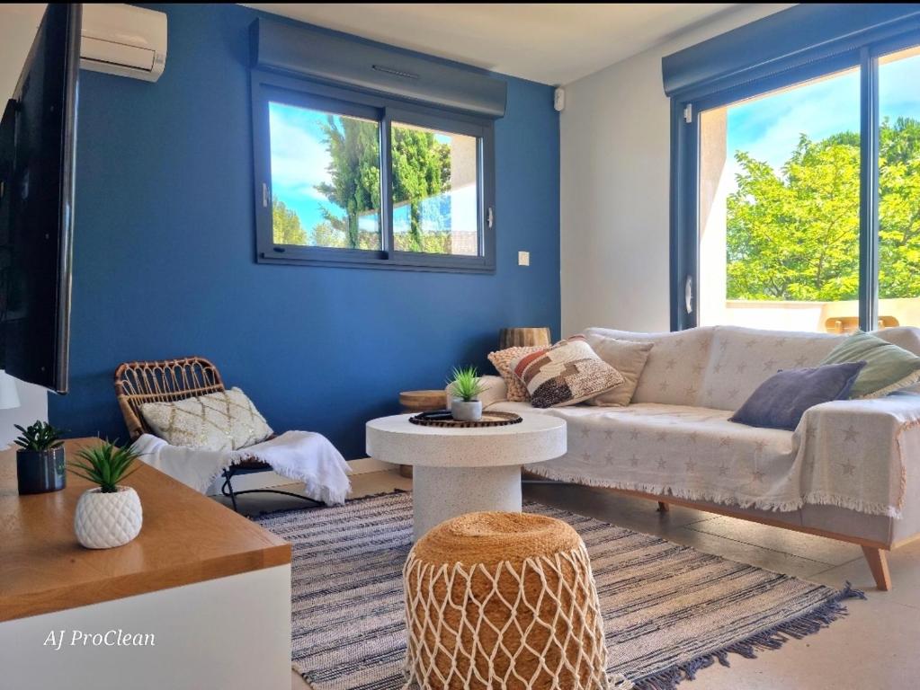salon z białą kanapą i niebieskimi ścianami w obiekcie L'ecrin d'Andréa - à 20min de la mer et 5min du centre, parking privé - By AURAconciergerie w mieście Saint-Cyr-sur-Mer