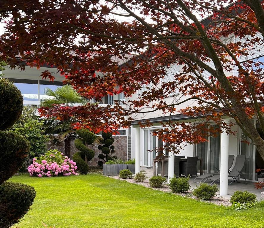 a house with a green yard with flowers at Villa GiNa Apartement in Albbruck