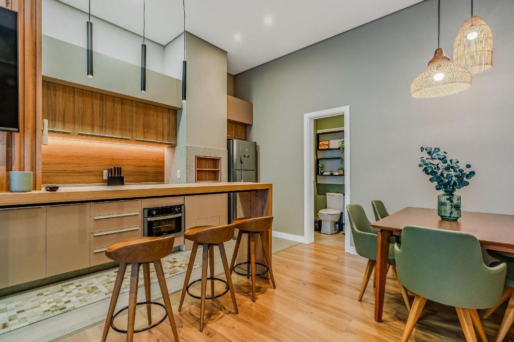 een keuken en eetkamer met een tafel en stoelen bij Luxo e Estilo no centro by Achei Gramado in Gramado