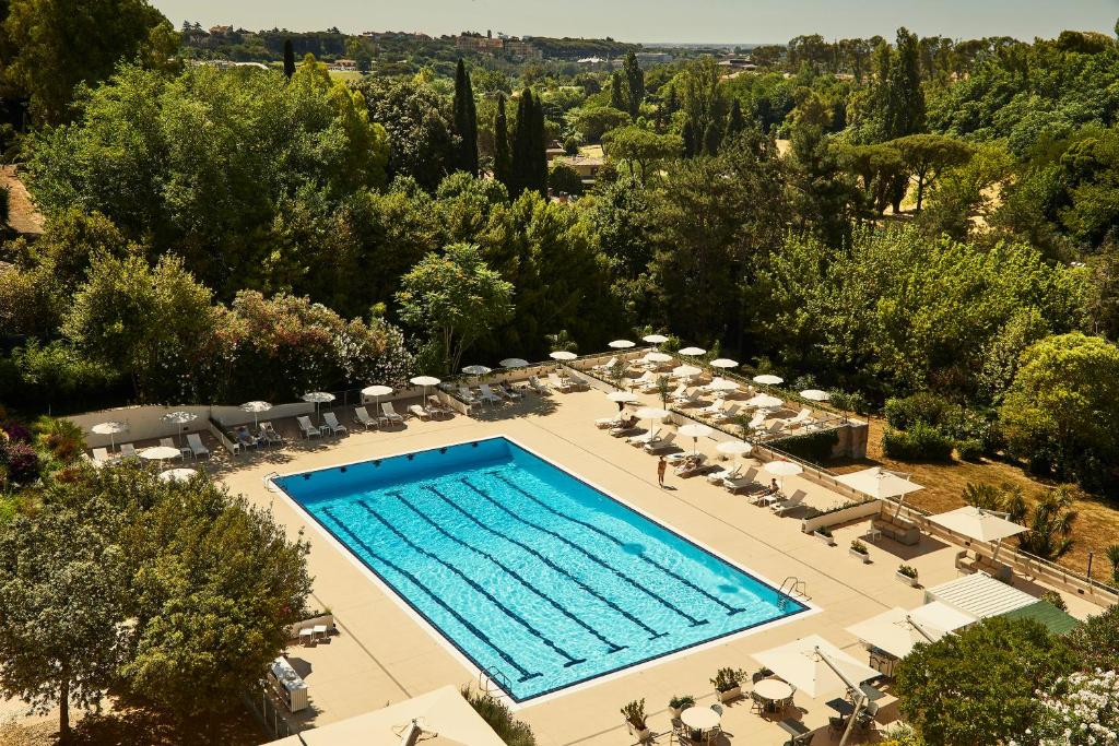 ローマにあるHotel Villa Pamphili Romaのスイミングプール(椅子、パラソル付)のオーバーヘッドビュー