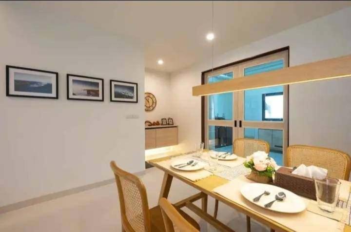 Un comedor con mesa y sillas de madera. en Modern House CNX, en Chiang Mai