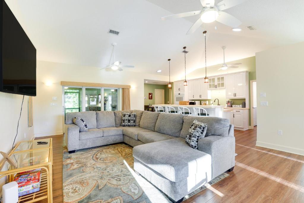 a living room with a couch and a kitchen at Pet-Friendly Fort Pierce Home with Screened Porch! in Fort Pierce