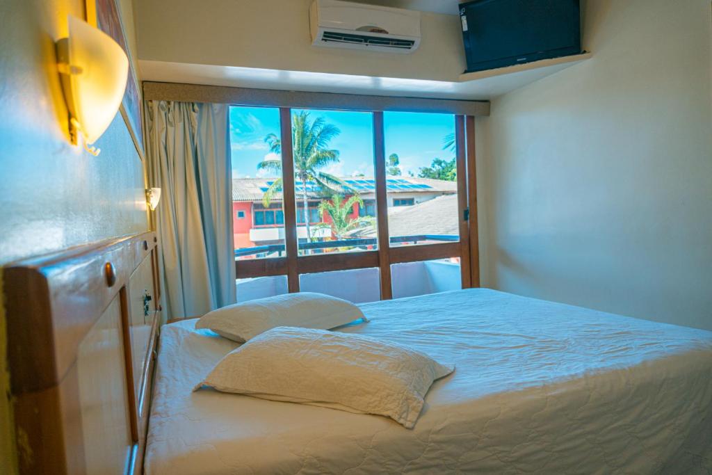 Cama ou camas em um quarto em Porto das Naus Praia Hotel