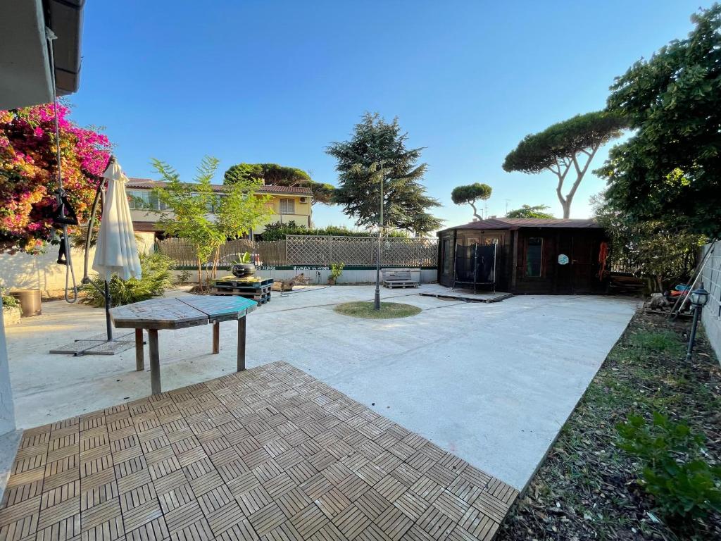 a patio with a table and an umbrella at Nerone's House Villa with garden near the sea, ideal for family in Anzio