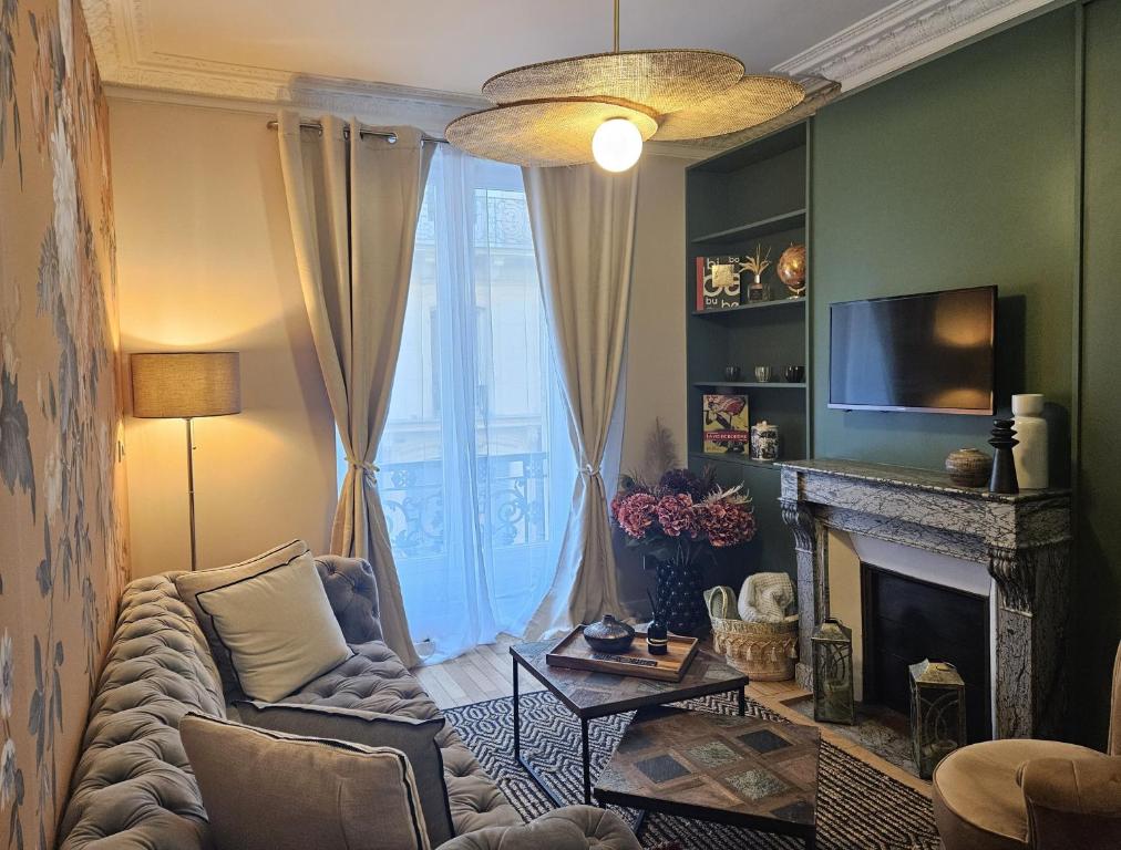 un salon avec un canapé et une cheminée dans l'établissement Chic Apartment By Capucine - Grands Magasins, à Paris