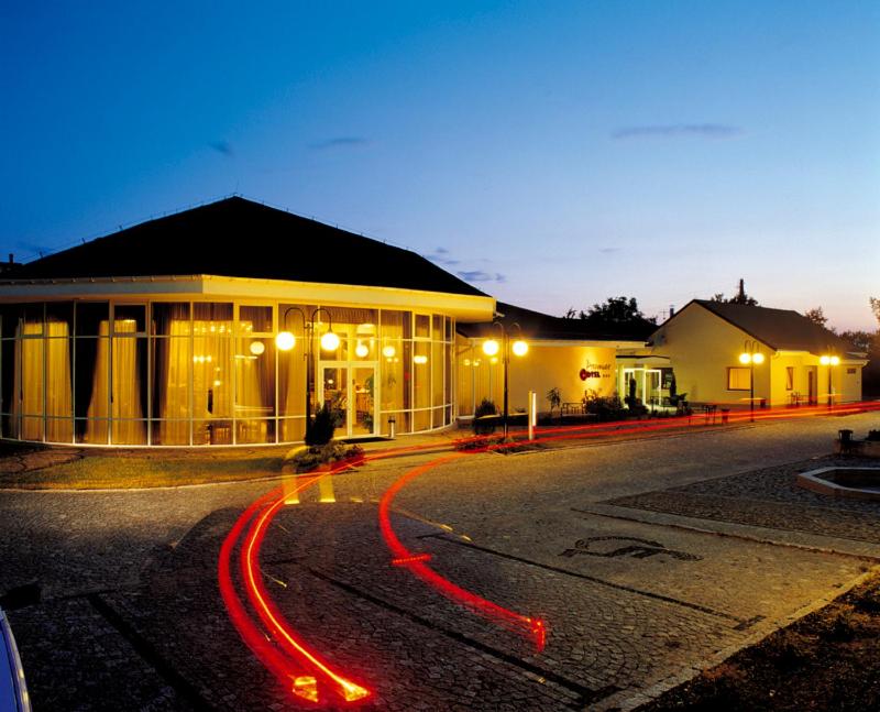 un bâtiment dans une rue la nuit avec des lumières rouges dans l'établissement Hotel Preemier, à Marcinowice