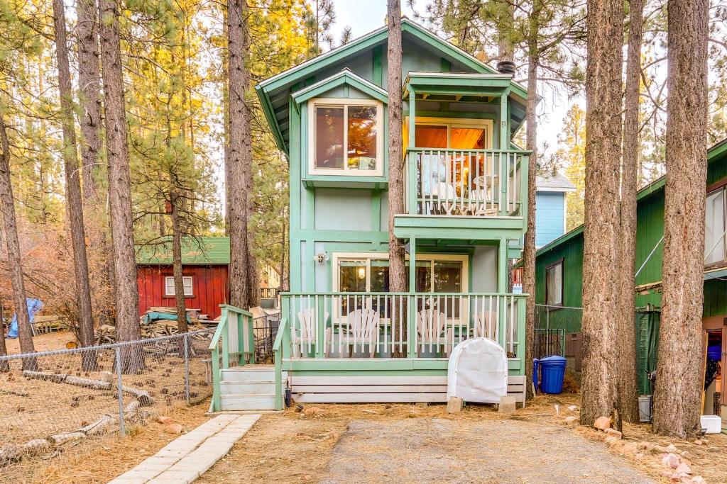 una casa verde con un balcón en los árboles en Near Skiing and Hiking Dog-Friendly Big Bear Cabin, en Big Bear City