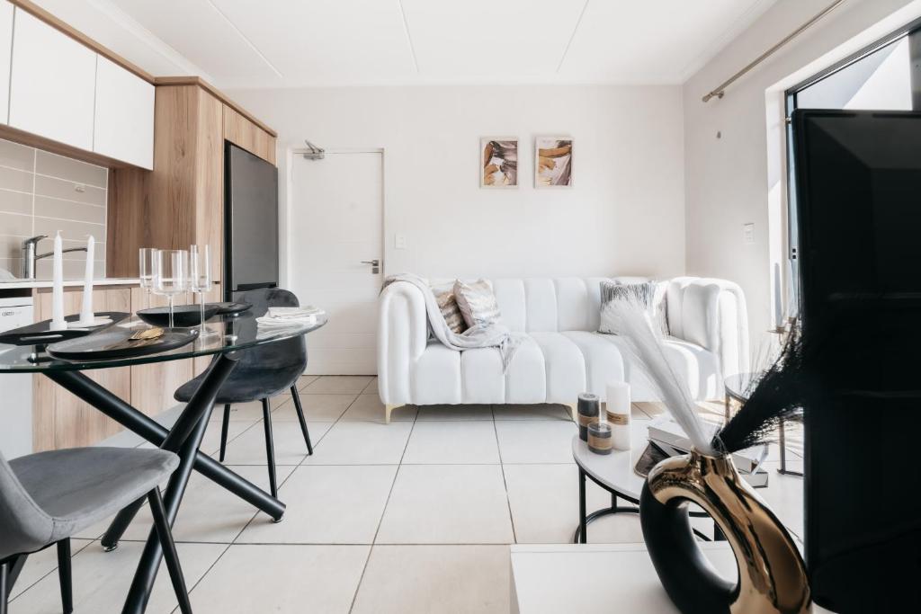a white living room with a white couch and a table at Exquisite Getaway - Luxury Apartment in Sandown