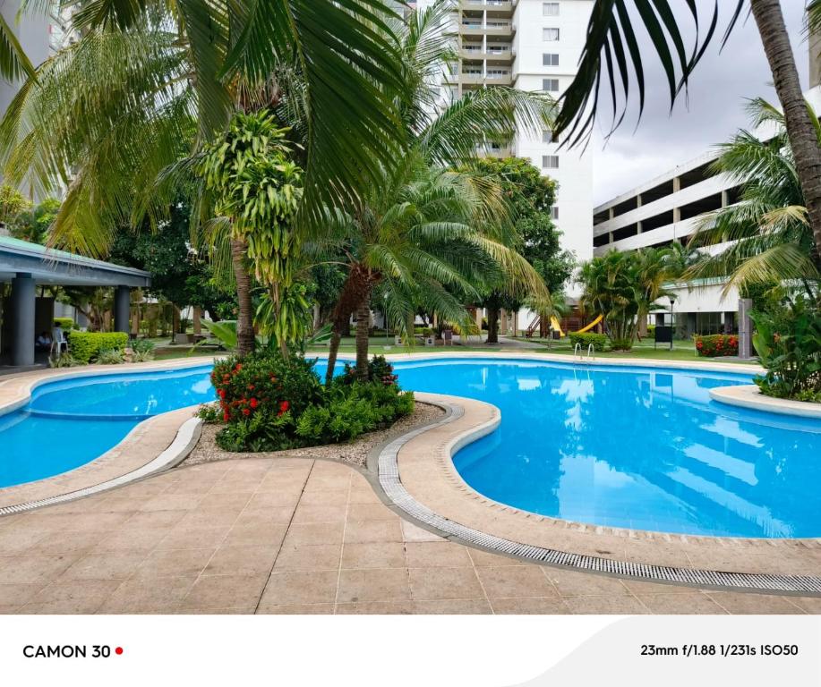 a swimming pool in a resort with palm trees at Hermoso departamento 91 MT2, PISCINA GRANDE y lindas áreas comunes in Santa Cruz de la Sierra