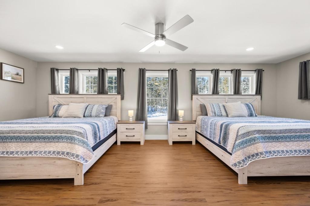 two beds in a bedroom with windows at Tide Song -10D in Bernard